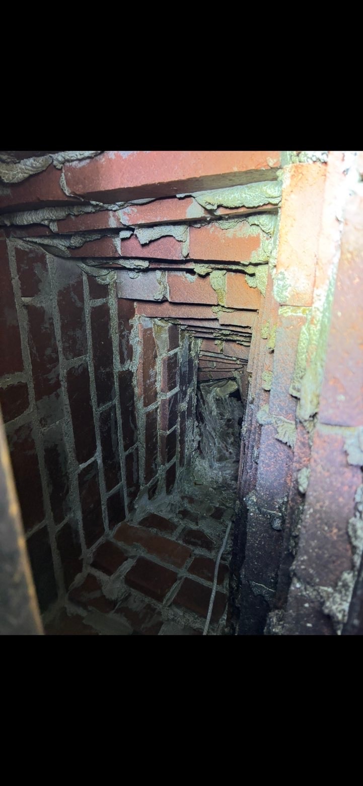Deteriorated chimney flue liner showing cracks and damage